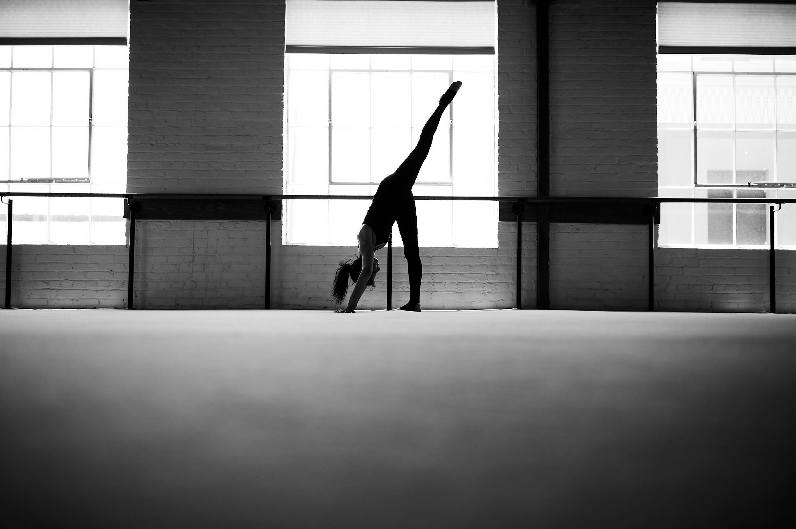 Solo barre client in studio in standing straddle stretch